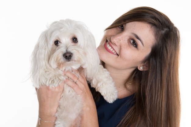 Mujer joven, con perro blanco, mirando feliz sonriendo