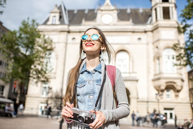 Foto mujer joven con photocamera viajando en el casco antiguo de la ciudad de luxemburgo