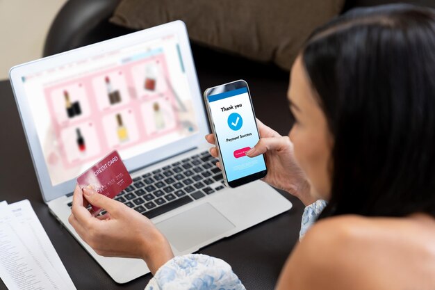 Mujer joven pide o compra un producto en Internet usando una computadora portátil y hace el pago de la transacción por teléfono inteligente Estilo de vida de compras en línea con tarjeta de crédito a través de la banca por Internet en la aplicación móvil Blithe.