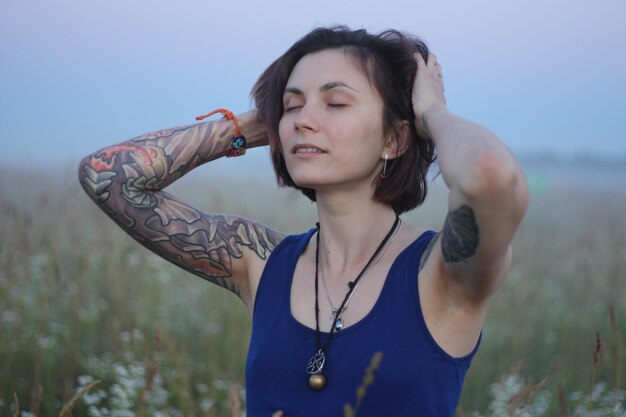 Foto mujer joven de pie en el campo