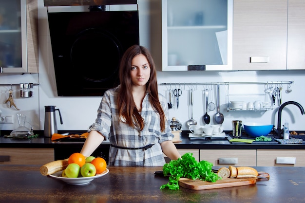 Mujer joven de pie en una cocina