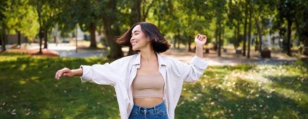 Mujer joven de pie contra los árboles