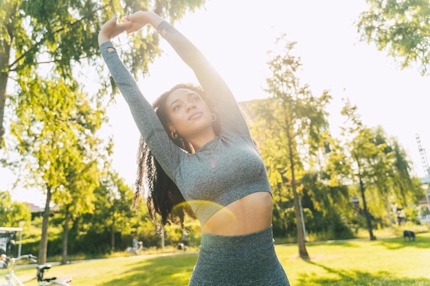 Mujer joven de pie contra los árboles
