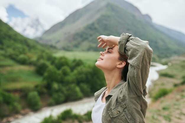 Foto mujer joven de pie contra la montaña