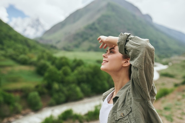 Foto mujer joven de pie contra la montaña