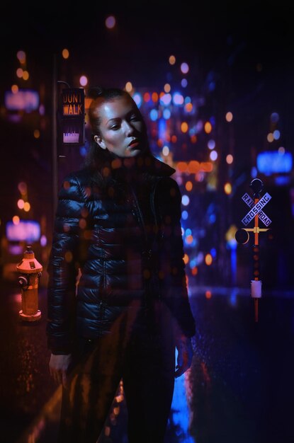 Foto mujer joven de pie frente a las luces iluminadas por la noche