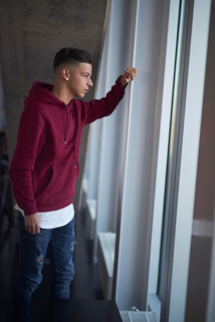 Foto mujer joven de pie junto a la ventana en casa