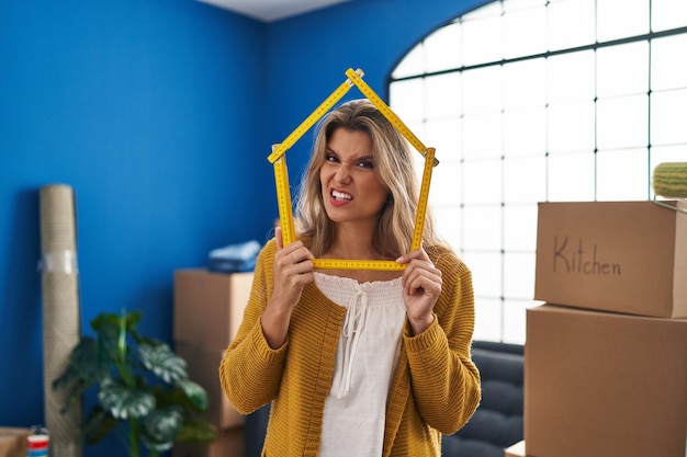 Foto mujer joven de pie en el nuevo hogar expresión desorientada y confusa. concepto de duda.