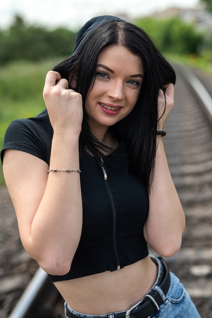 Mujer joven de pie sobre un ferrocarril, viaje en tren en vacaciones de verano.