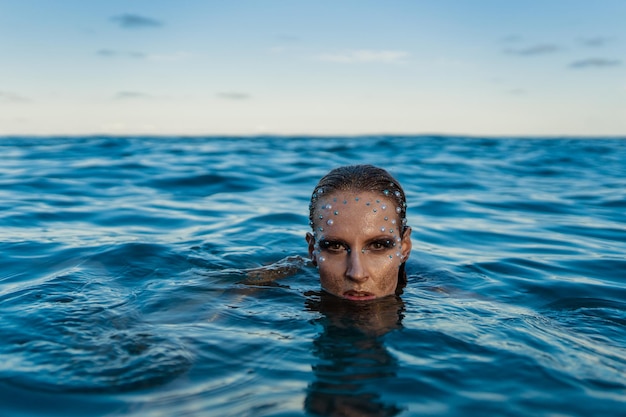 Mujer joven con piel dorada en el agua