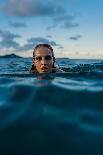 Mujer joven con piel dorada en el agua