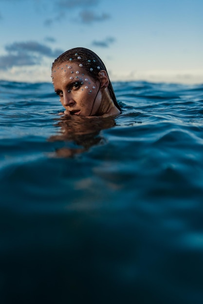 Mujer joven con piel dorada en retrato acuático