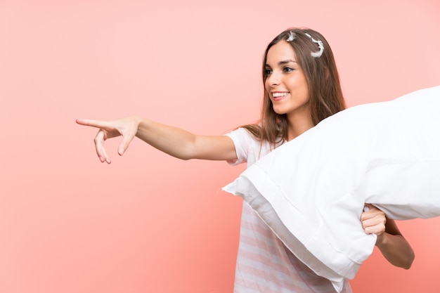 Mujer joven en pijama aislado rosa