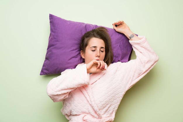 Mujer joven en pijama bostezando