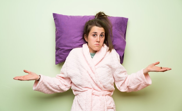 Mujer joven en pijama haciendo gesto sin importancia