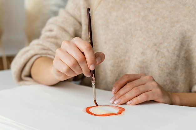 Mujer joven pintando con acuarelas sobre papel