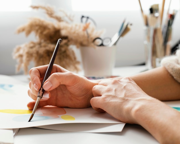 Foto mujer joven pintando con acuarelas