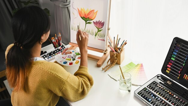 Foto mujer joven pintando sobre un lienzo en casa