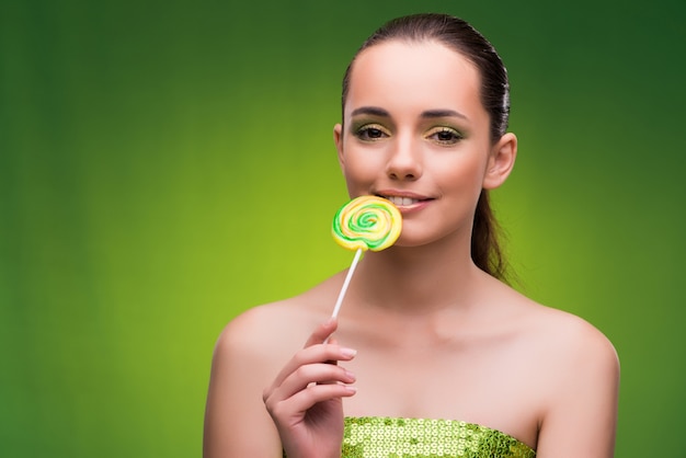 Foto mujer joven con piruleta en verde