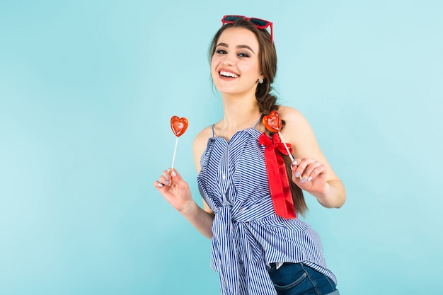 Mujer joven con piruletas en forma de corazón