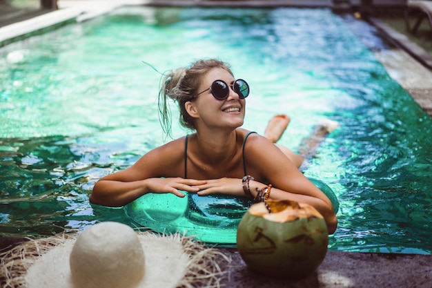 Mujer joven en la piscina, tiempo para relajarse.