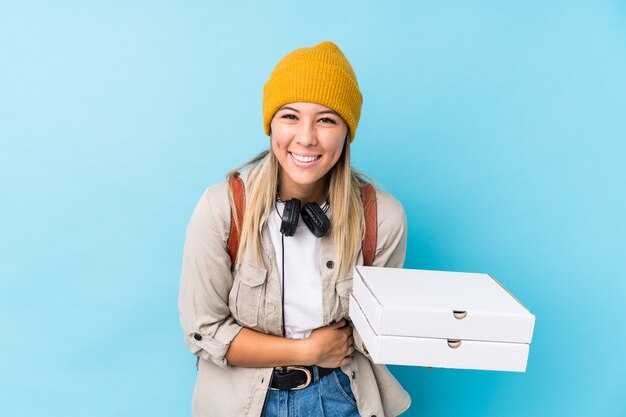 Mujer joven con pizzas riendo y divirtiéndose.