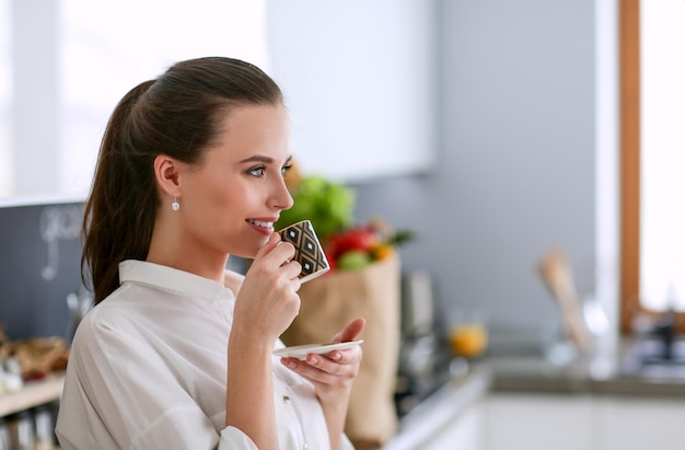 Mujer joven planeando gastos y pagando facturas en su cocina