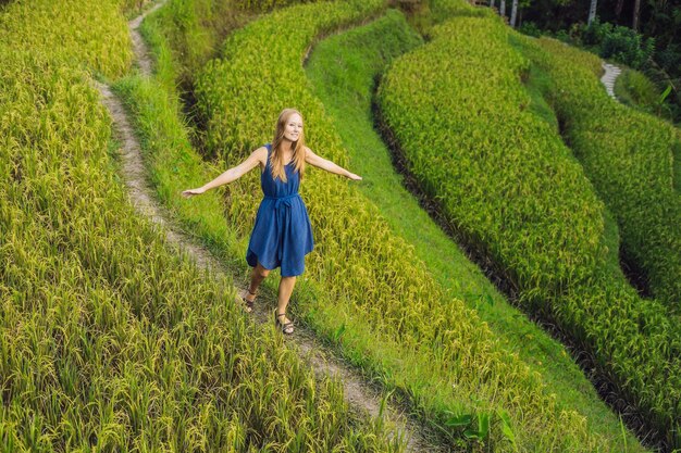 Mujer joven en la plantación de campo de arroz en cascada verde en la terraza de Tegalalang. Bali, Indonesia