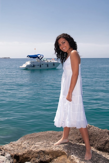 mujer joven en la playa disfrutando del buen tiempo cerca del mar