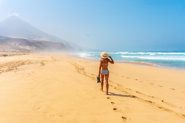 Una mujer joven en la playa salvaje Cofete del parque natural de Jandia Fuerteventura
