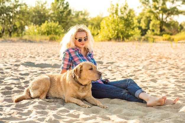 Mujer joven en la playa con su perro