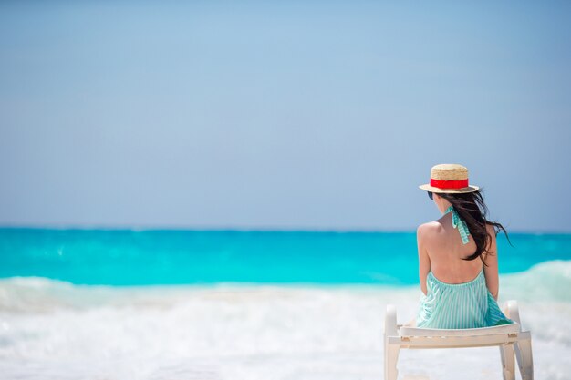 Mujer joven en una playa tropical con sombrero