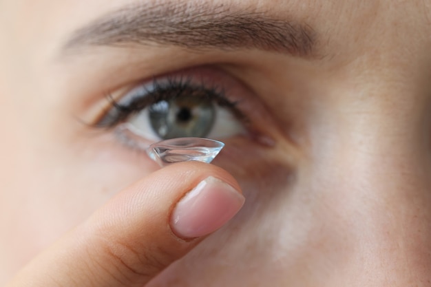 Mujer joven poniéndose lentes de contacto selección de concepto de lentes de contacto