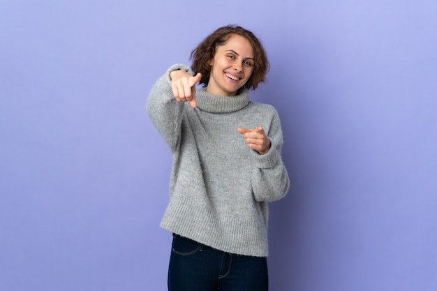 Mujer joven posando aislada contra la pared en blanco