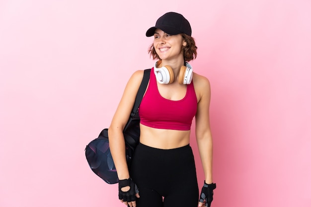 Mujer joven posando aislada contra la pared en blanco