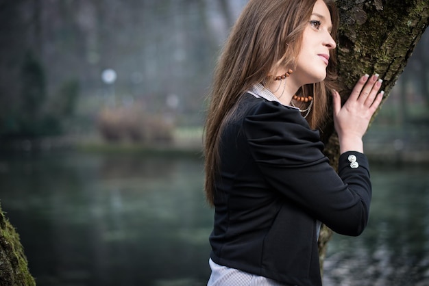 mujer joven posando en el árbol