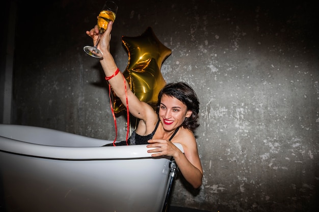 Foto mujer joven posando en la bañera en casa