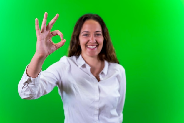 Foto mujer joven posando bien mano fondo verde