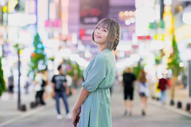 Mujer joven posando en la ciudad de Tokio por la noche