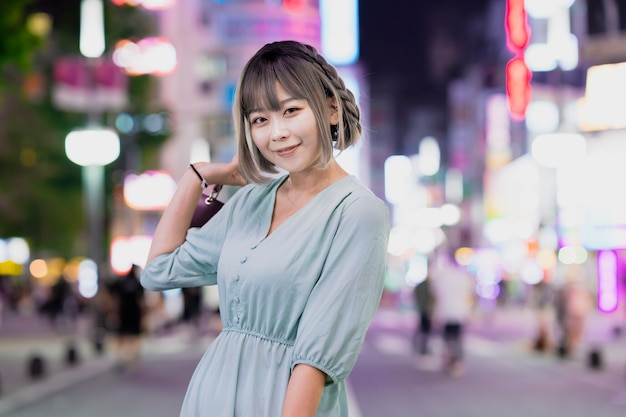 Mujer joven posando en la ciudad de Tokio por la noche