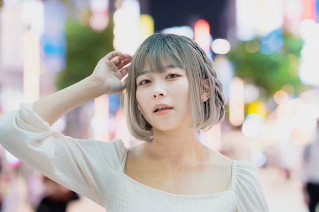 Mujer joven posando en la ciudad de Tokio por la noche