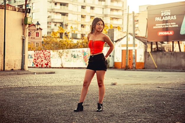 Mujer joven posando frente a algunos edificios