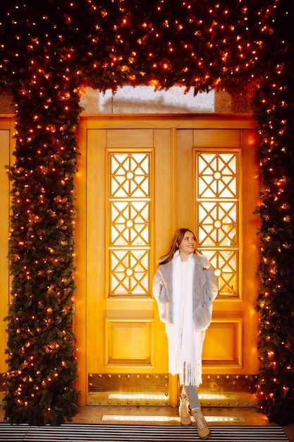 Foto mujer joven posando junto al árbol de navidad en vacaciones de invierno con estrella de navidad.