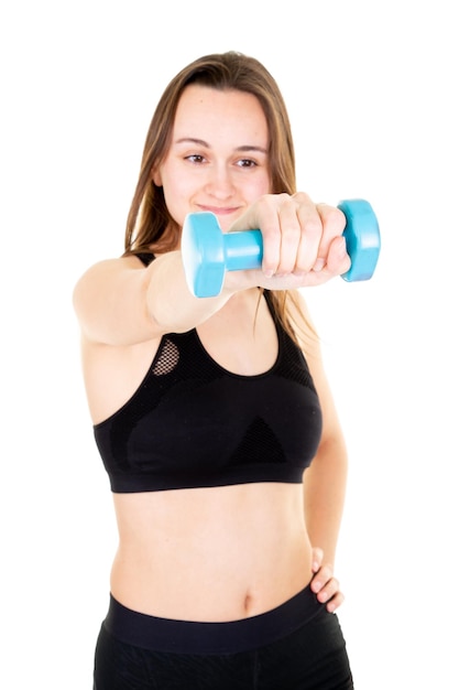 Mujer joven posando con pesas azules en ropa de fitness sobre fondo blanco.