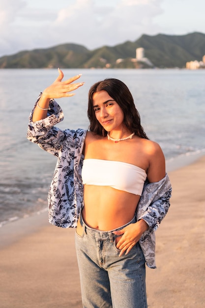 mujer joven, posar, en la playa, durante, ocaso