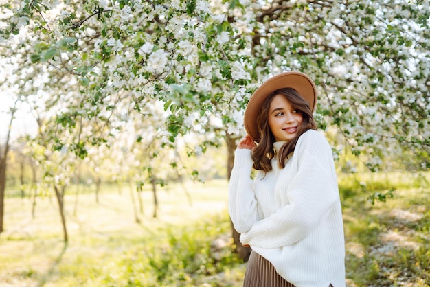 mujer joven, posar, en, primavera, flor, flores, en, floreciente, jardín, belleza femenina, moda