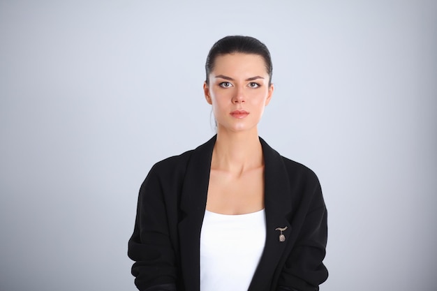 Foto mujer joven, posición, aislado, en, fondo gris