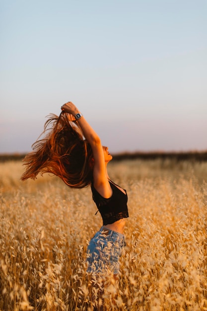 mujer joven, posición, en, campo grano, el gozar, ocaso