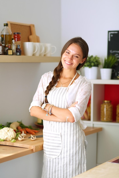 mujer joven, posición, cerca, escritorio, en la cocina