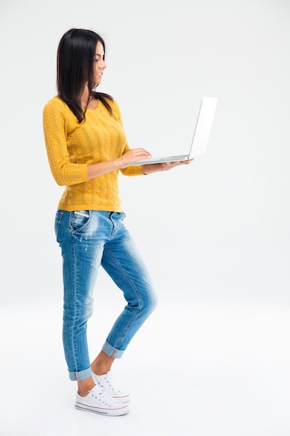 Mujer joven, posición, y, utilizar la computadora portátil
